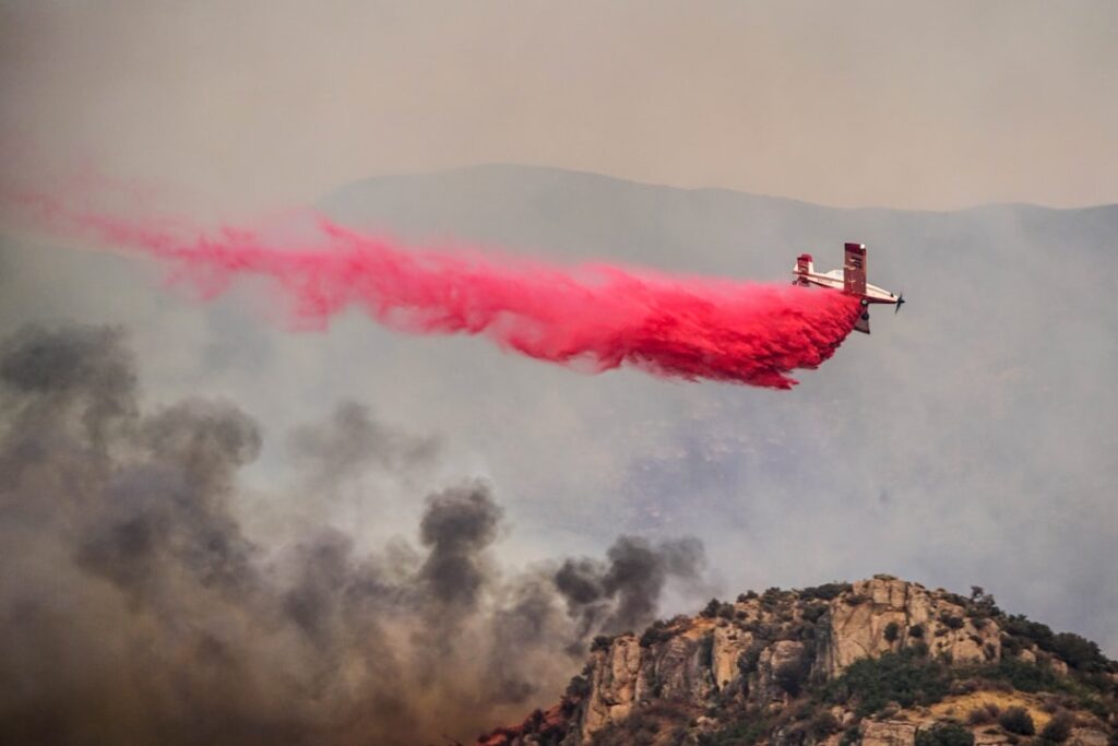 Flames consume hillside homes in Pacific Palisades as orange smoke billows over gridlocked evacuation traffic under fierce Santa Ana winds