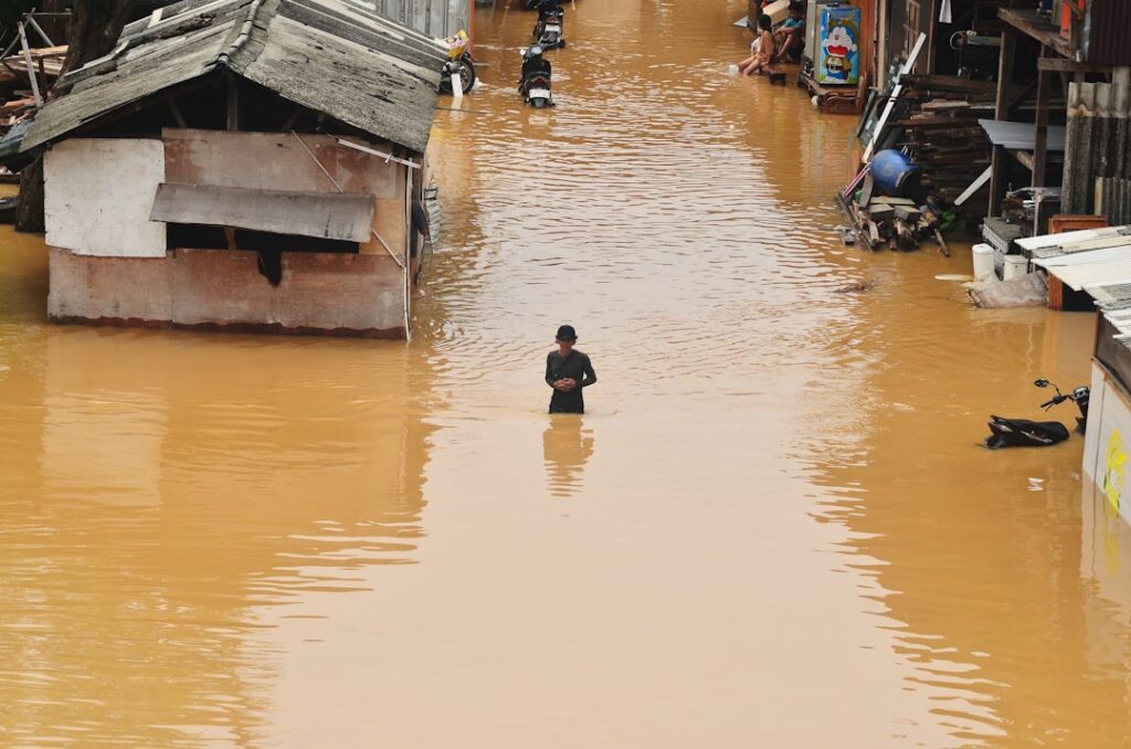 Rescue workers wade through a flooded street in Dubai after record rainfall submerged roads and damaged buildings.