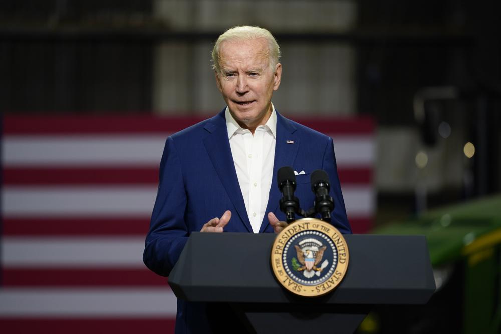 President Joe Biden speaks at a podium in Menlo, Iowa, announcing an ethanol rule waiver to reduce gasoline prices.