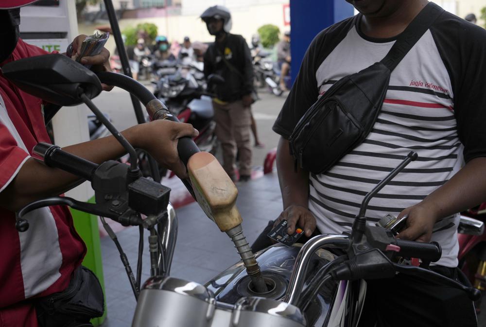 Motorcycle-taxi drivers queue at a Pertamina fuel pump in Jakarta, Indonesia, as fuel prices rise by 30%.