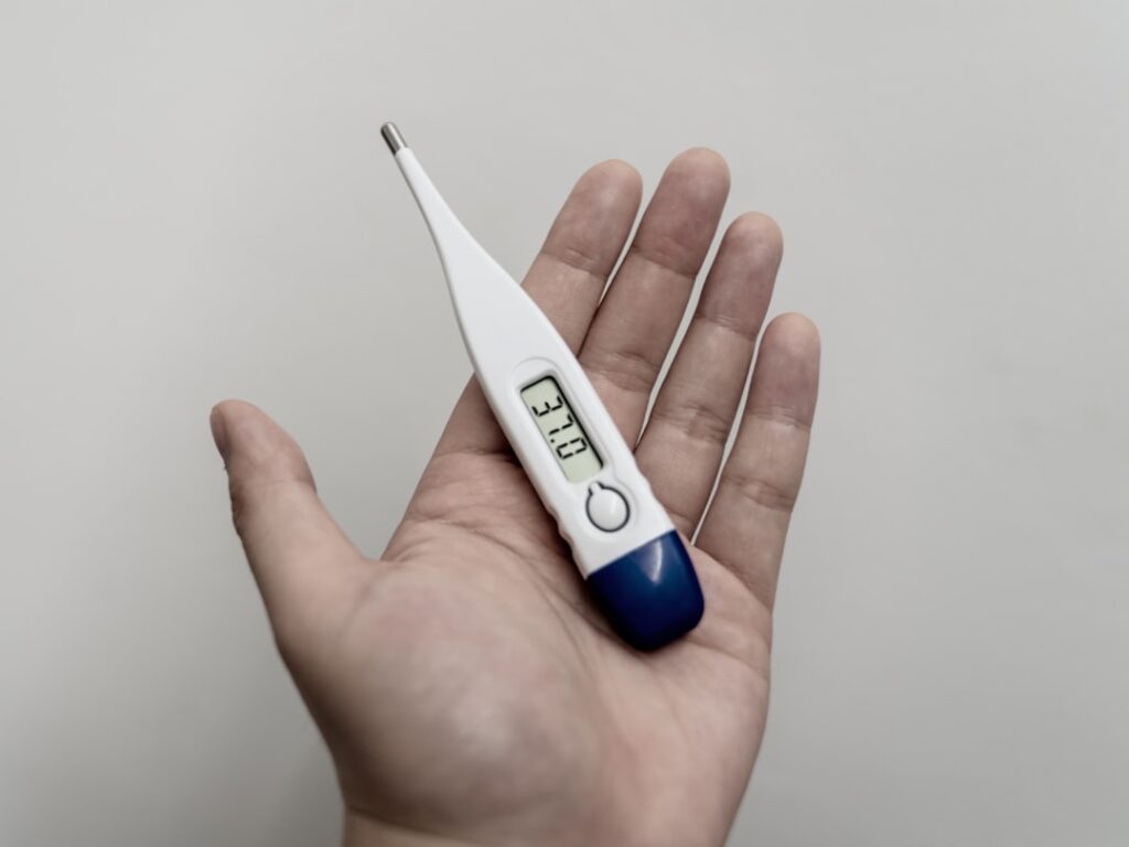 Medical staff wheel heatstroke patients into an overcrowded emergency ward as outdoor thermometer hits 45 °C under a motionless anticyclone.
