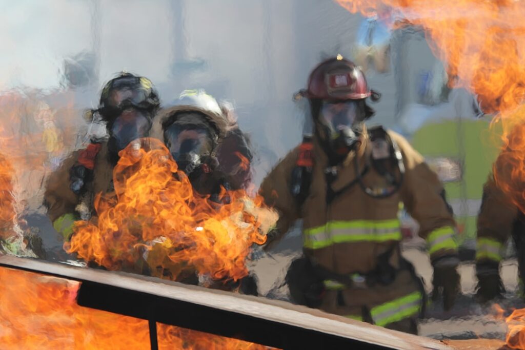 Firefighters and emergency responders outside a smoke-damaged Milan nursing home building after the deadly July 2023 fire.