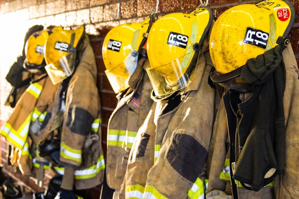Firefighters work outside a charred three-story guesthouse after an overnight blaze that left ten dead.