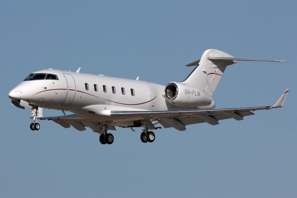 A Bombardier Challenger 300 business jet on a runway, with emergency vehicles nearby after an accident.