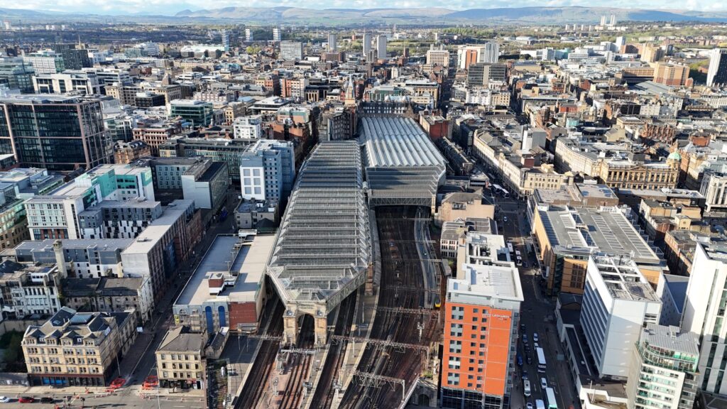 Firefighters battle a large blaze engulfing a historic building next to Glasgow Central railway station, with smoke billowing over the city.